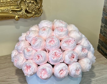 May include: A white box filled with a large arrangement of pale pink silk peonies.
