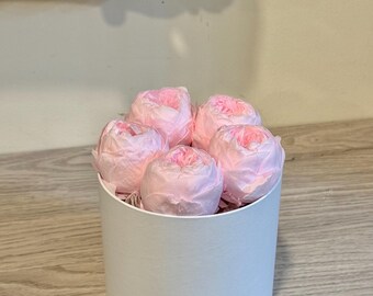 May include: A white cylindrical box with a lid filled with five pink peonies.