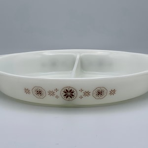 May include: Cream-coloured oval divided serving dish with a brown floral and starburst design. The dish has two compartments and handles. A vintage kitchenware item.