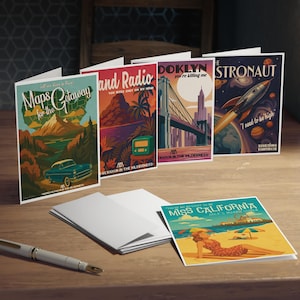 May include: A collection of vintage-style greeting cards with travel-themed illustrations. The cards feature images of a car, a radio, a bridge, a rocket, and a woman on a beach. The text on the cards includes "Maps for the Getaway", "Land Radio", "Doklyn", "Astronaut", and "Miss California".