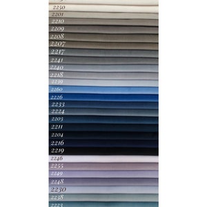 May include: A color chart of Magic Velvet fabric swatches. The swatches are arranged in rows from lightest to darkest, starting with a white swatch and ending with a dark blue swatch. The swatches are numbered with their corresponding color code.