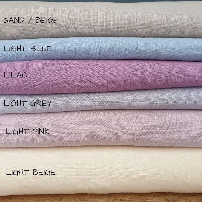 May include: Six fabric swatches stacked on top of each other. The swatches are in the following colors from top to bottom: sand/beige, light blue, lilac, light grey, light pink, and light beige.