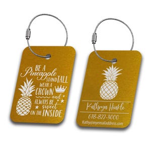May include: Gold luggage tag with a pineapple design and the text "Be a Pineapple Stand Tall Wear a Crown and Always Be Sweet on the Inside". The tag also includes a name, phone number, and email address.
