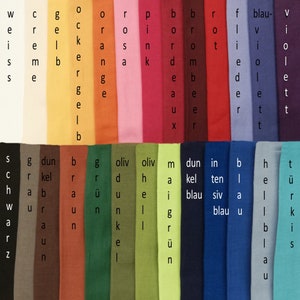 Könnte beinhalten: Eine Sammlung von Stoffproben in verschiedenen Farben, darunter Schwarz, Weiß, Rot, Blau, Grün, Braun und Gelb. Die Proben sind in Reihen und Spalten angeordnet, und jede Probe ist mit einem deutschen Wort beschriftet.