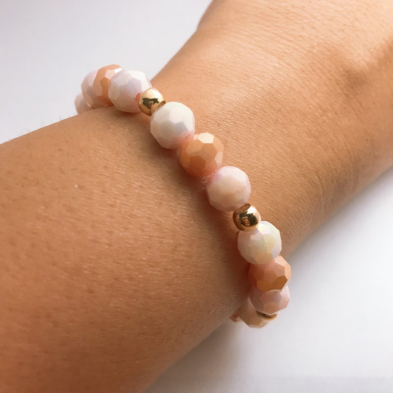 May include: A bracelet with peach and white faceted beads and gold spacers.