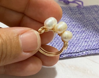 May include: A gold wire ring with a cluster of five white pearls.