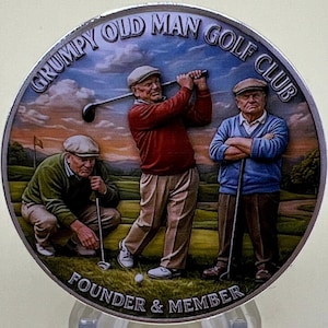 May include: A round metal golf club emblem with the text "GRUMPY OLD MAN GOLF CLUB" and "FOUNDER & MEMBER". The image depicts three older men playing golf on a green course, with one swinging a club. The emblem has a silver border.