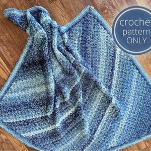 May include: A blue and white crochet blanket with a textured pattern. The blanket is folded in half and has a light blue and white ombre effect.