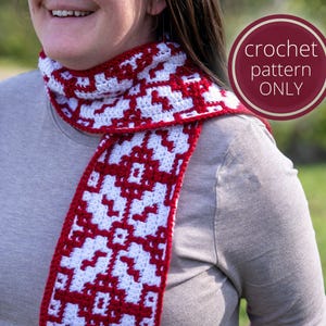 May include: A red and white crochet scarf with a geometric pattern. The scarf is worn by a person in a grey shirt. The image includes the text "crochet pattern ONLY".