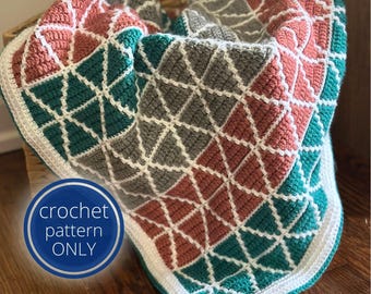May include: A crocheted blanket featuring a geometric pattern of triangles in teal, coral, and grey, outlined with white yarn. A circular blue badge in the corner displays the white text crochet pattern ONLY. The blanket has a white border.