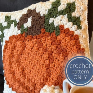 May include: Crochet pattern for a pumpkin pillow. The pillow is made with orange, brown, white, and green yarn. The pattern is available for download.
