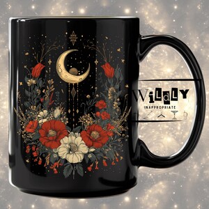 Puede incluir: Taza de cerámica negra con un diseño floral que incluye flores rojas y blancas, una luna creciente y estrellas. La taza tiene un asa negra y el texto "WiLaLy INAPPROPRIATE".