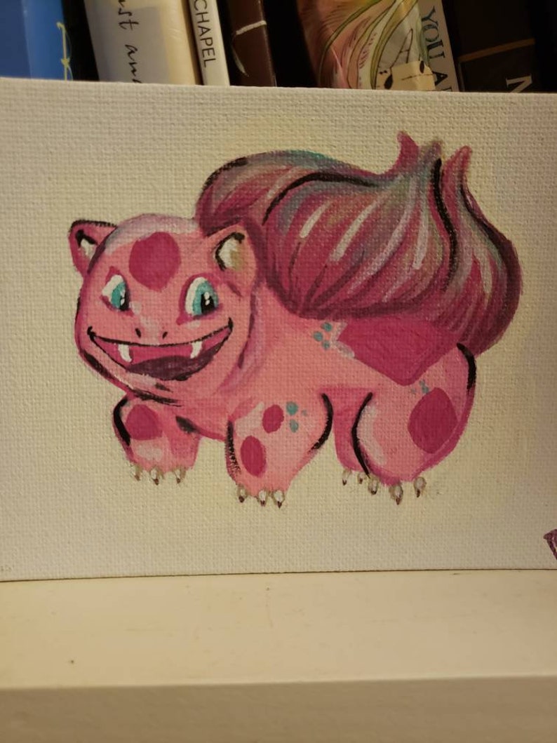 Puede incluir: Un lienzo pintado a mano con un personaje de dibujos animados rosa con una cola rosa grande y ojos azules. El personaje tiene manchas rosas y garras blancas.