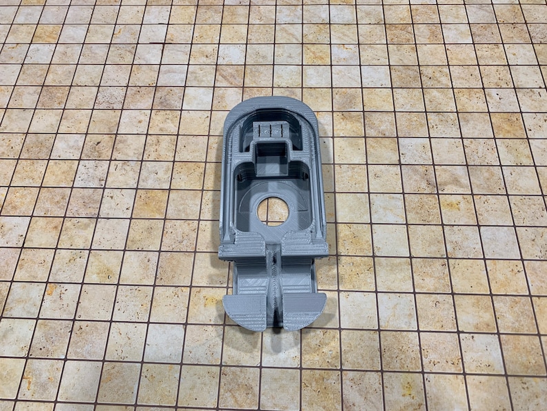 May include: A gray 3D printed model of a spaceship with a cockpit and a rear thruster.