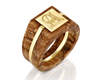 May include: A wooden ring with a gold band and a square gold top featuring an engraved letter "P".