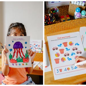 Puede incluir: Una ni&ntilde;a sostiene una hoja de trabajo "Colorea por n&uacute;mero" con una medusa morada, coral rojo y algas verdes. La hoja de trabajo es parte de un conjunto de actividades educativas. Se ven otras hojas de trabajo y materiales de arte.