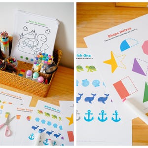 Puede incluir: Una cesta de mimbre llena de materiales de arte, incluyendo crayones, rotuladores y l&aacute;pices de colores, junto a hojas de actividades impresas. Las hojas presentan p&aacute;ginas para colorear, ejercicios de emparejamiento de formas y de conteo.