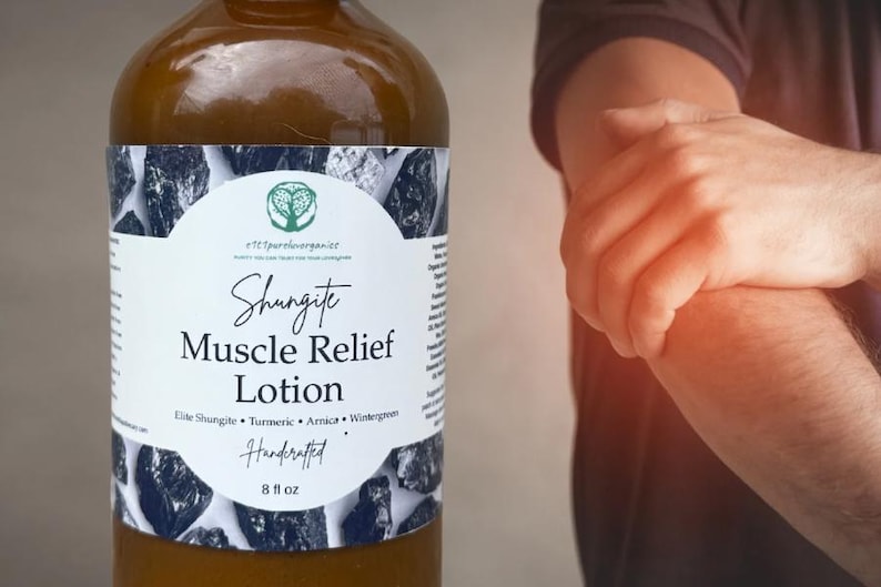 Peut inclure: Une bouteille en verre marron de lotion Shungite Muscle Relief, environ 237 ml, avec une &eacute;tiquette blanche orn&eacute;e de graphiques de pierres noires et grises. L'&eacute;tiquette indique "Elite Shungite, Turmeric, Arnica, Wintergreen" et "Handcrafted".
