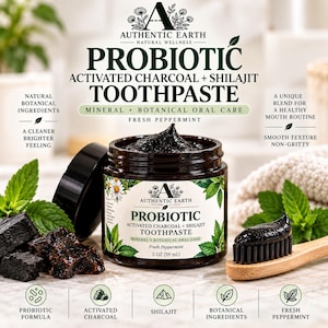 Könnte beinhalten: Ein Tiegel Authentic Earth Probiotic Activated Charcoal + Shilajit Zahnpasta mit schwarzem Deckel. Das Etikett zeigt botanische Illustrationen, den Text 2 OZ (59 mL) und Fresh Peppermint. Eine Holzzahnbürste mit schwarzer Paste liegt daneben.