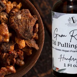 以下が含まれることがあります： Gum Repair Oil Pulling Blend with Green Hojari Frankincense、1 Fl ozとラベルが貼られた濃い琥珀色のガラス瓶と、表面がざらざらした茶色とオレンジ色の樹脂製のお香の塊が入った木製のボウル。