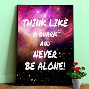 Könnte beinhalten: Ein gerahmter Kunstdruck mit einem lebendigen Nebeldesign in Pink-, Lila- und Orangetönen. Der weiße Text lautet: „THINK LIKE A QUARK AND NEVER BE ALONE!“ Eine kleine Topfpflanze mit roten Blüten steht daneben.