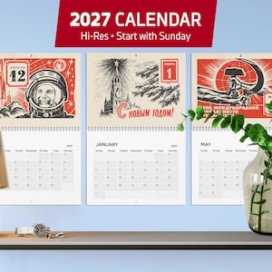 May include: A 2027 wall calendar featuring three pages with Soviet-style graphic illustrations. The pages display monthly grids for April, January, and May, with red, black, and white color schemes, including imagery of a cosmonaut and a hammer and sickle.