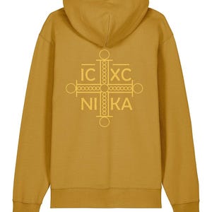 May include: Mustard-coloured hoodie with a hood and long sleeves. The back of the hoodie features a gold-coloured cross design with the Greek letters IC XC NIKA.