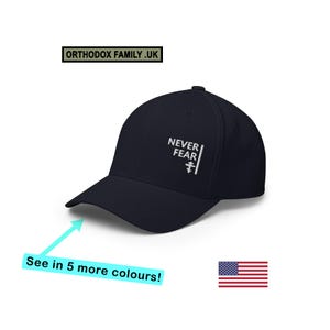 May include: A navy blue baseball cap featuring white embroidered text that reads NEVER FEAR with a small Orthodox cross symbol below the text. The cap has a structured crown and a curved brim, presented with a logo box reading ORTHODOX FAMILY.UK.