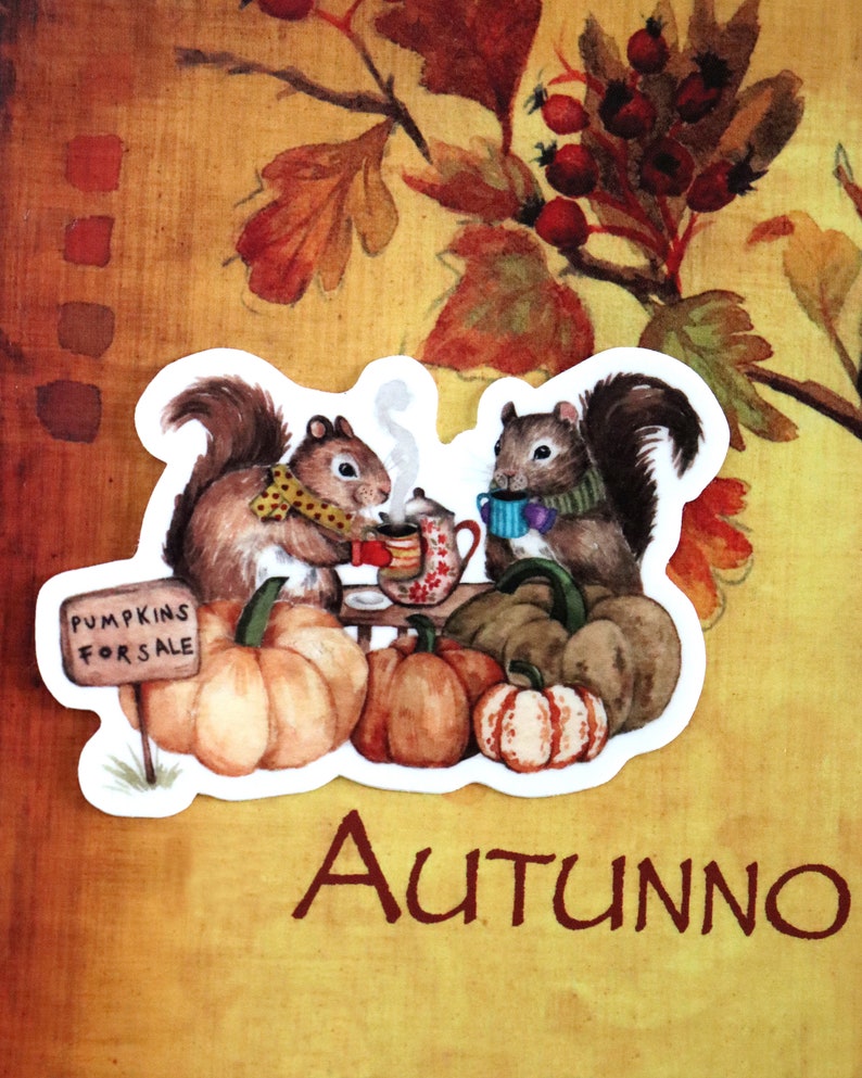 May include: Two squirrels wearing scarves and hats are sitting at a table with a teapot and mugs. They are surrounded by pumpkins and a sign that says "Pumpkins for Sale".