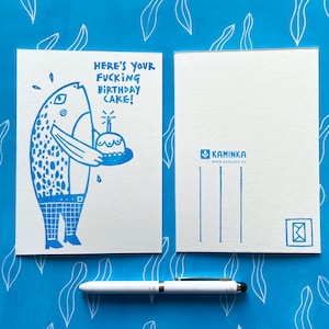 Könnte beinhalten: Blaue und weiße illustrierte Postkarte mit einem Comic-Fisch, der einen Geburtstagskuchen hält. Der Text auf der Karte lautet "Here's your fucking birthday cake!"