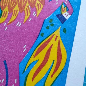 以下が含まれることがあります： ピンク色の人物と黄橙色のディテールが青い背景に描かれた抽象的なイラスト。黄色と赤の炎の形が際立っています。白いアクセントと白いボーダーも表示され、印象的な視覚的構成を作り出しています。