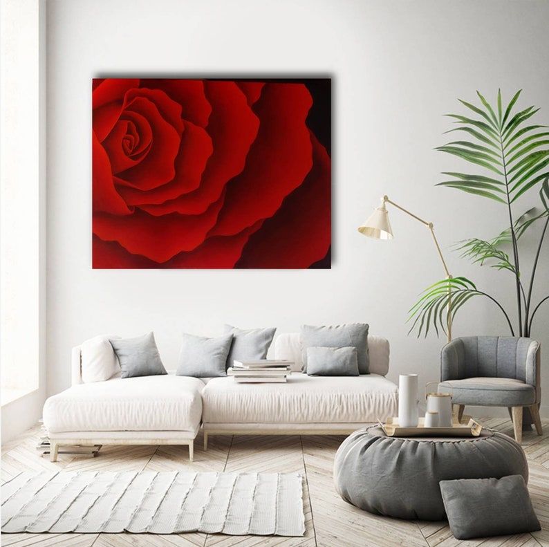 May include: A close-up of a red rose with petals that are curled and layered. The rose is in focus, while the background is blurred.