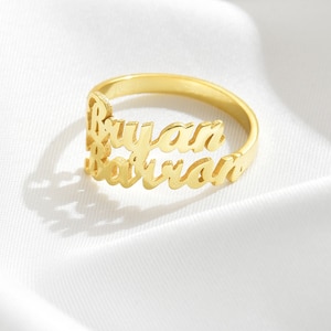 Peut inclure: Bague en or avec les noms "Bryan" et "Barron" gravés en écriture cursive.