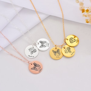 May include: Three silver, gold, and rose gold necklaces with personalized pet portraits on round pendants. The pendants feature the names "Ellie", "Bailey", and "Ellie".