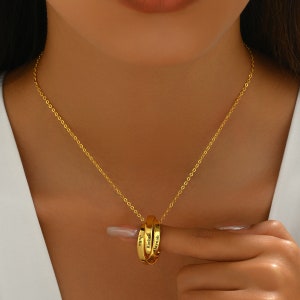May include: Gold chain necklace with three interlocking rings, each engraved with a name: "Julia", "Rachel", and "Marynah".