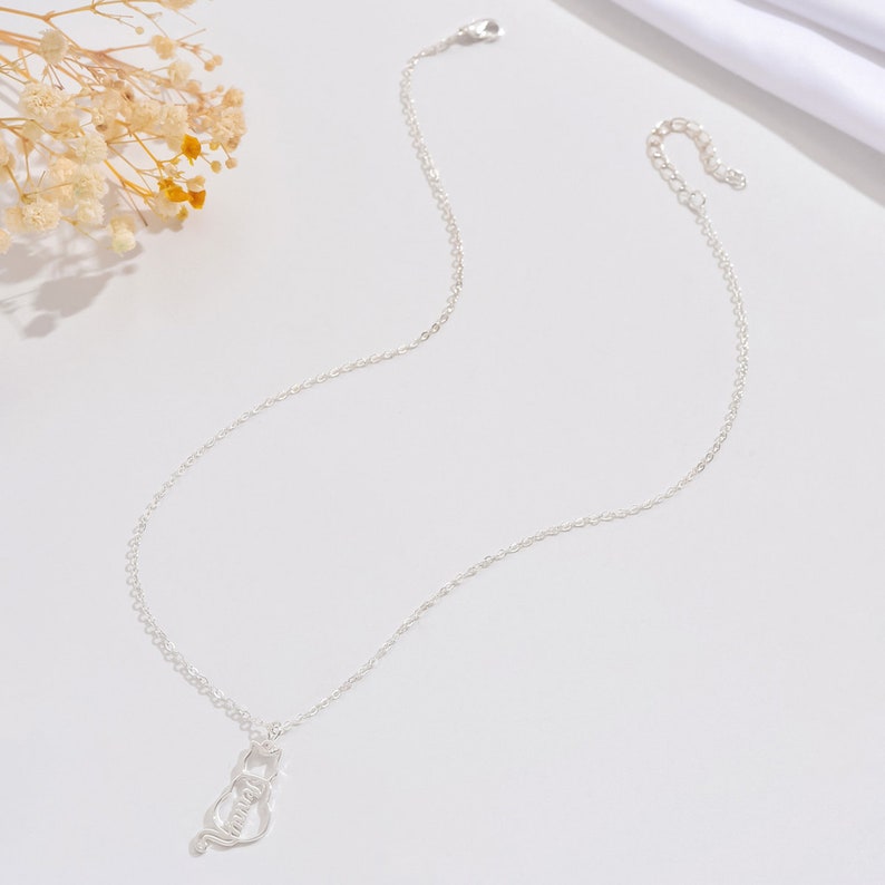 May include: A silver chain necklace with a pendant that says "Mommy" in a stylized font.