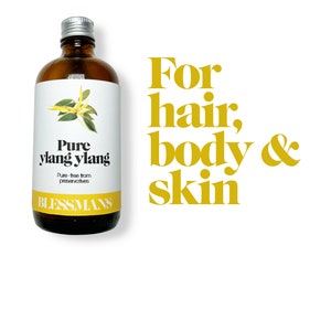 May include: A brown glass bottle with a silver lid and a white label that reads "Pure ylang ylang" and "Pure - free from preservatives" with a yellow flower illustration. The bottle is labeled "Blessmans". The text "For hair, body & skin" is in yellow letters on a white background.