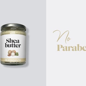 May include: A glass jar of shea butter with a white label that says "Shea butter" and a drawing of shea nuts. The label also says "Blessmans". The background is light gray. The text "No Parabens" is written in gold on a white background.