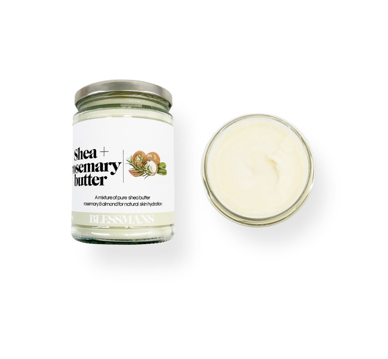 May include: A glass jar of shea and rosemary butter with a white label that reads "Shea + Rosemary Butter" and "A mixture of pure shea butter, rosemary & almond for natural skin hydration." The label also includes a small illustration of shea nuts, rosemary sprigs, and almonds. The jar is sitting on a white background.