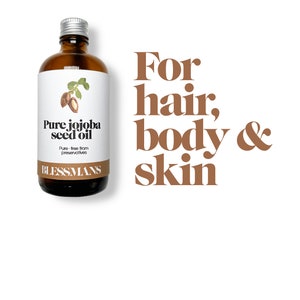 May include: A brown glass bottle with a silver lid and a white label that reads "Pure jojoba seed oil". The label also says "Pure - free from preservatives" and "BLESSMANS". The bottle is sitting on a white background with the text "For hair, body & skin" in brown letters.