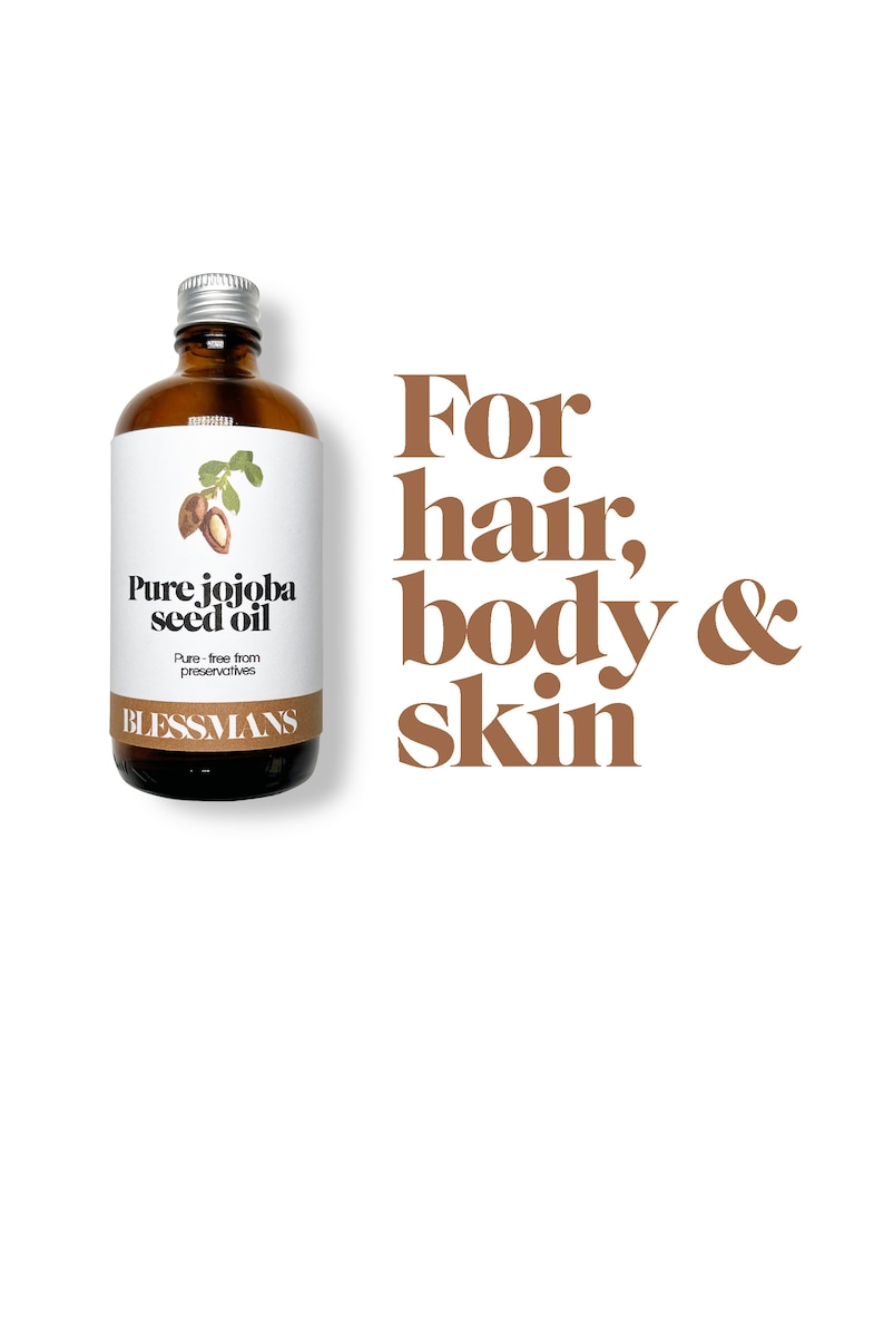May include: A brown glass bottle with a silver lid and a white label that reads "Pure jojoba seed oil". The label also says "Pure - free from preservatives" and "BLESSMANS". The bottle is sitting on a white background with the text "For hair, body & skin" in brown letters.