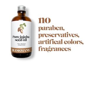 May include: A brown glass bottle with a silver lid containing pure jojoba seed oil. The label reads "Pure jojoba seed oil" and "Pure - free from preservatives". The bottle is sitting on a white background with the text "no paraben, preservatives, artificial colors, fragrances" in brown text.