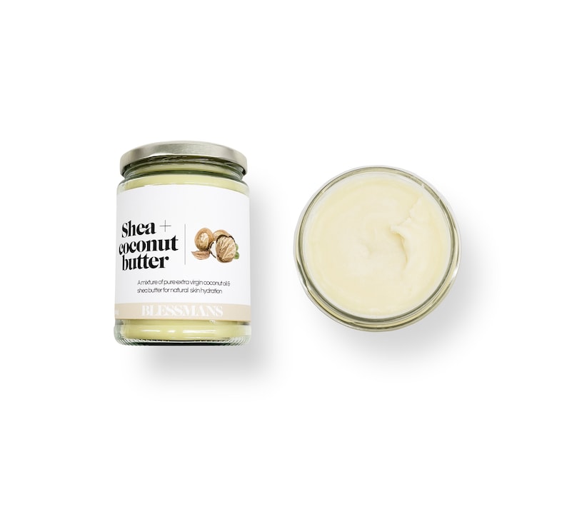 Pode incluir: Um frasco de vidro de manteiga de karit&eacute; e coco com um r&oacute;tulo branco que diz "Shea + coconut butter" e "Uma mistura de &oacute;leo de coco extra virgem puro e manteiga de karit&eacute; para uma hidrata&ccedil;&atilde;o natural da pele." O r&oacute;tulo tamb&eacute;m apresenta uma pequena ilustra&ccedil;&atilde;o de um coco e uma noz de karit&eacute;. O frasco est&aacute; sobre um fundo branco.