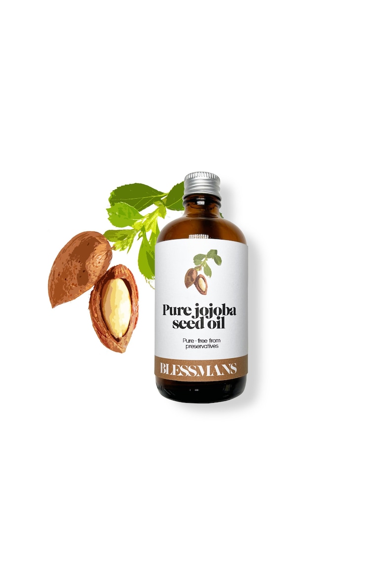 May include: A brown glass bottle with a silver lid and a white label that reads "Pure jojoba seed oil. Pure - free from preservatives. BLESSMANS". The bottle is surrounded by green leaves and two brown jojoba seeds.