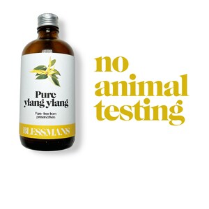 May include: A brown glass bottle with a silver lid, containing pure ylang ylang essential oil. The label is white with black text that reads "Pure ylang ylang" and "Pure-free from preservatives". The bottom of the label reads "Blessmans". The text "no animal testing" is written in yellow letters on a white background.