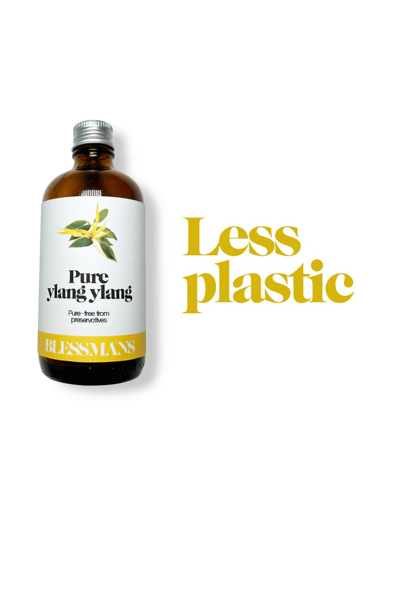 May include: A brown glass bottle with a silver lid and a white label. The label says "Pure ylang ylang" and "Pure - free from preservatives". The bottle is sitting on a white background with the text "Less plastic" in yellow letters.