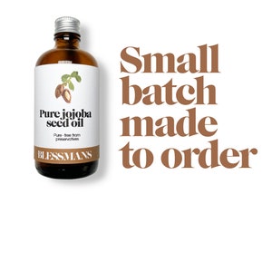 May include: A clear glass bottle with a silver lid filled with jojoba seed oil. The label reads "Pure jojoba seed oil" and "Pure - free from preservatives". The bottle is labeled "Blessmans". The text "Small batch made to order" is written in brown text on a white background.