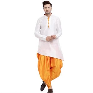 May include: A white long-sleeved kurta with a mandarin collar and a vertical row of orange buttons, paired with bright orange dhoti pants. The ensemble features a smooth, slightly reflective fabric finish and a clean, structured design.