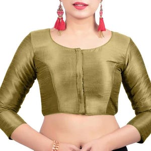 Op de afbeelding: Een olijfgroene blouse met lange mouwen, een ronde halslijn en een knoopsluiting. De blouse heeft een subtiele glans en een getailleerde pasvorm. De mouwen zijn lang en nauwsluitend. De stof lijkt een glad, geweven materiaal te zijn. De blouse is effen van kleur.