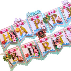 May include: A colorful banner with the words "HAPPY BIRTHDAY MOANA" in gold, pink, and blue. The banner features images of characters, flowers, and tropical elements. Perfect for a Moana-themed birthday party.